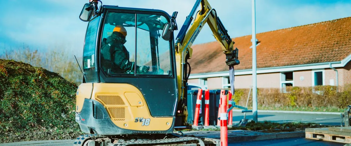 Mini excavator on rubber tracks working on a construction site — the same tracked undercarriage technology that makes mini track dumpers effective on soft and uneven terrain