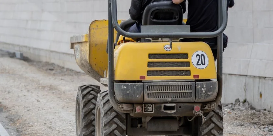 Two workers operating a dumper on a construction site