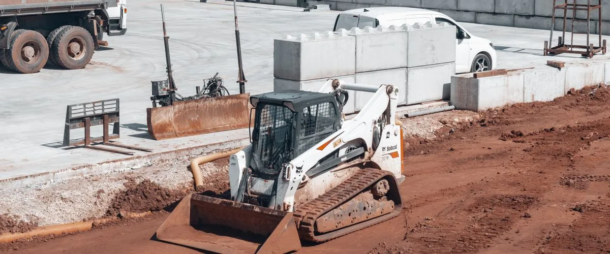 Bulldozer with front loading blade working on a construction site — the same front-blade principle that defines the self-loading mini dumper's autonomous loading mechanism