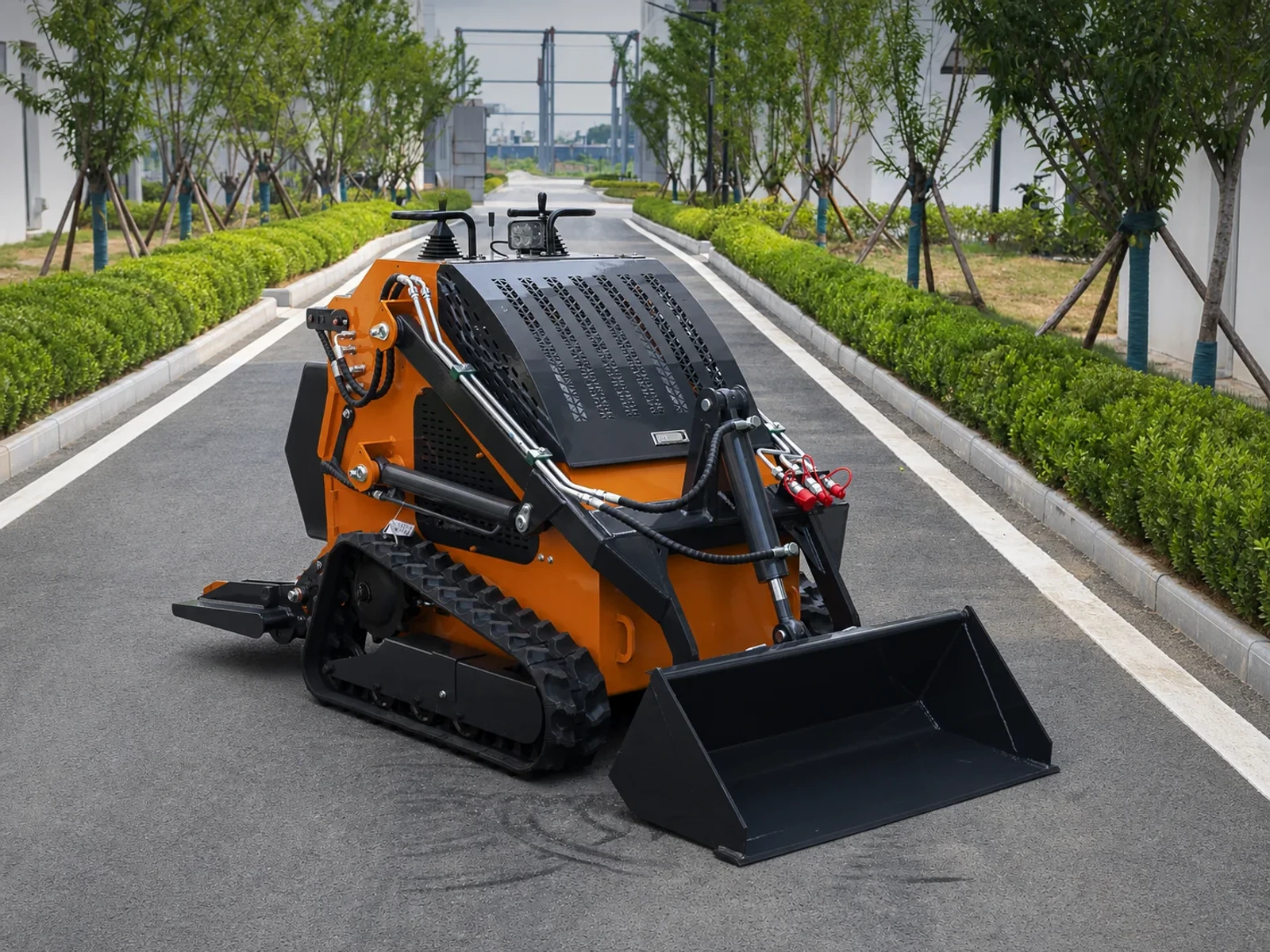 Mini skid steer loader in a compact tracked stand-on format for narrow-access jobsite work